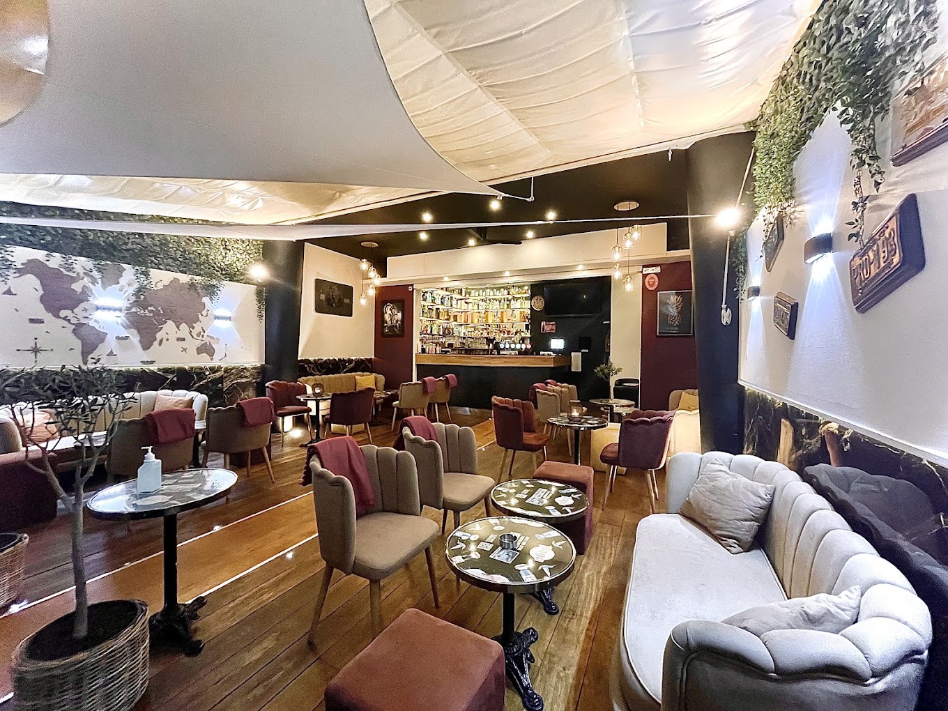 Salon du bar Blend, banquettes de velours et mappemonde murale